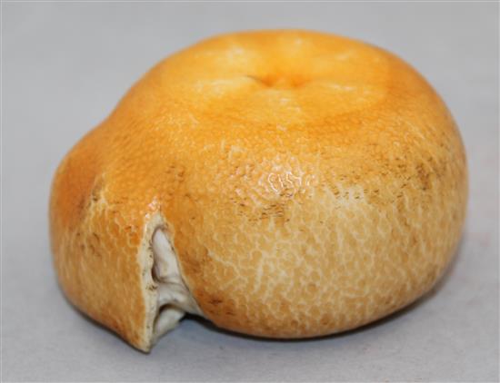 A Japanese coloured ivory model of a partially peeled satsuma, early 20th century, 7cm.